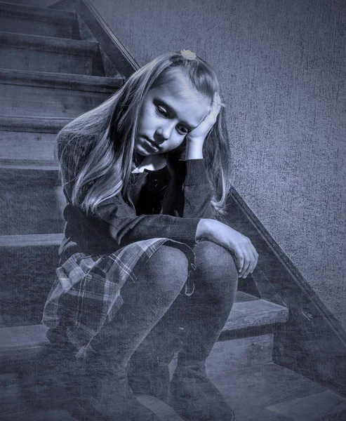 Niña de 7 u 8 años triste deprimida y preocupada sentada en la escalera desesperada y asustada sufriendo acoso escolar — Foto de Stock