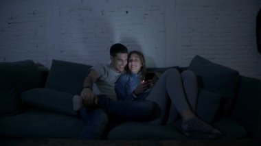 Genç mutlu ve romantik çift birlikte istimal hareket eden telefon oturma zevk onların 20s üzerinde tarama ve eğlenmek internet uygulaması ile internet bağımlılığı kavramında koltuk kanepe Anasayfa