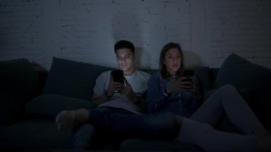 Genç çift cep telefonu evde kanepede oturup birbirimizi görmezden yorgun kullanarak kendi 20s üzerinde Internet app iletişim ve akıllı telefon bağımlılık kavramı ilişki eksikliği konsantre