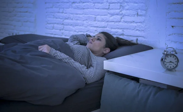 Young beautiful sad and worried latin woman suffering insomnia and sleeping disorder problem unable to sleep late at night lying on bed awake — Stock Photo, Image