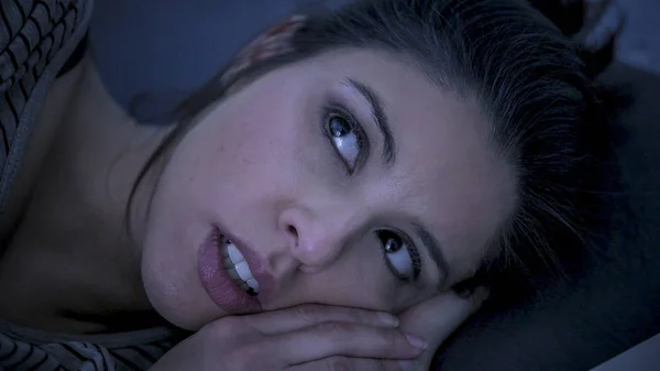 Молодая красивая грустная и беспокойная латинская женщина, страдающая бессонницей и бессонницей, не может спать допоздна, лежа на кровати бодрствуя. — стоковое фото