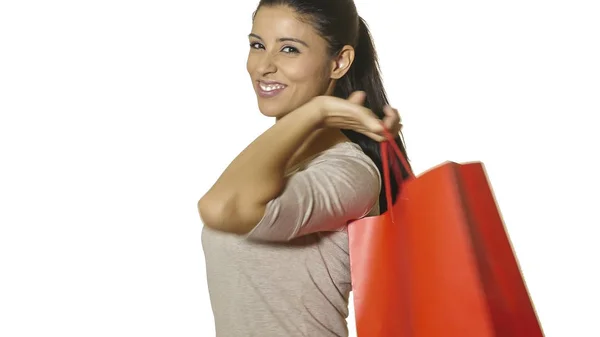 Jovem atraente e feliz mulher latina segurando saco de compras vermelho sorrindo alegre e positivo isolado no fundo branco em vendas e oportunidades conceito — Fotografia de Stock