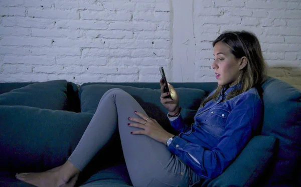 Νεαρή 20s ελκυστική γυναίκα ξαπλωμένη στον καναπέ Αρχική καναπές χρήση internet στο κινητό τηλέφωνο συμπυκνωμένα και χαλαρή εφαρμογή εθισμού — Φωτογραφία Αρχείου