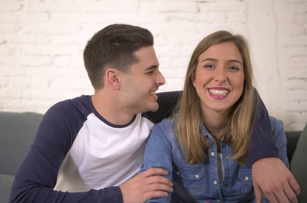 Jovem atraente casal feliz e romântico namorado e namorada abraçar concurso em casa sofá sorrindo brincalhão em belos adolescentes amor — Fotografia de Stock