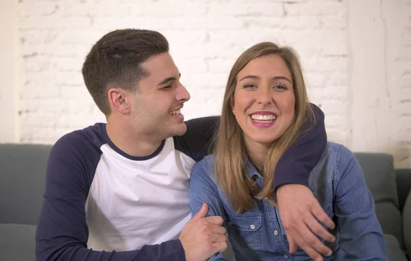 Młoda atrakcyjna para szczęśliwy i romantyczny chłopak i dziewczyna przytulać przetargu na domowej kanapie uśmiechnięty zabawny w miłości piękne Nastolatki — Zdjęcie stockowe