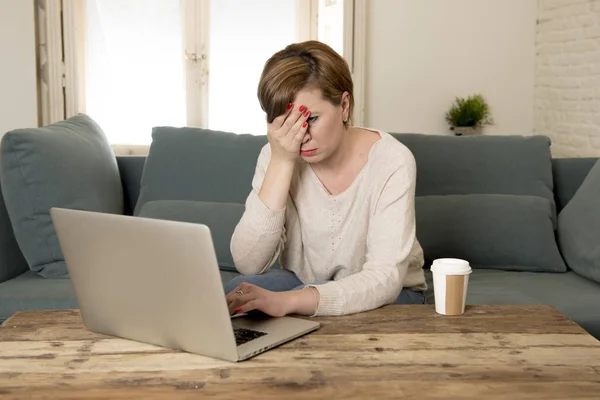 Junge attraktive und beschäftigte Frau zu Hause Sofa Couch dabei einige Laptop-Computer-Arbeit im Stress suchen besorgt in Unternehmer-Lebensstil — Stockfoto