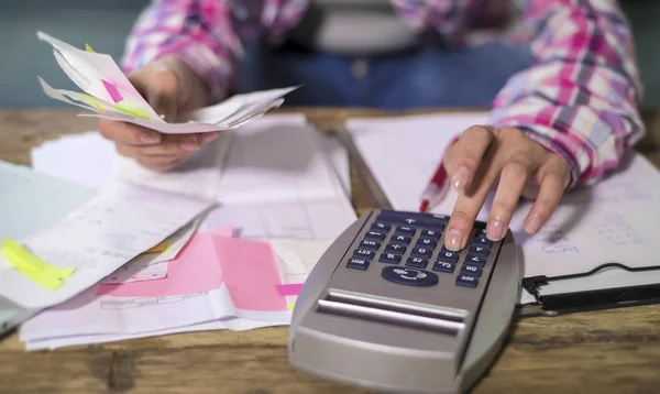 Ansiktslösa anonyma kvinna händer arbetar med bank pappersarbete räkningar och ekonomiska dokument beräkning av månatliga utgifter och skulder med miniräknare — Stockfoto