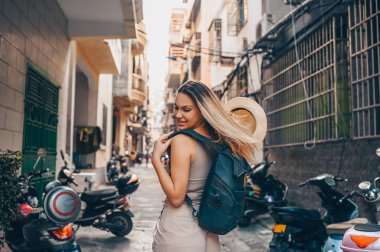 Genç Asyalı gezgin sarışın sırt çantalı kadın hasır şapkalı turist Sanya 'da açık havada eğleniyor. Asya boyunca seyahat, aktif yaşam tarzı konsepti. Hainan 'ı keşfetmek, Çin