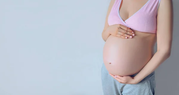 无法辨认的孕妇牵着手捂住大肚子 肚子里还抱着婴儿的孤立画像 未出生和期望的概念 复制可供模拟文本的自由空间 — 图库照片