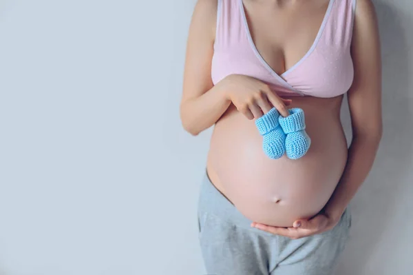 Retrato Aislado Mujer Embarazada Irreconocible Sosteniendo Zapatos Bebé Ganchillo Azul — Foto de Stock