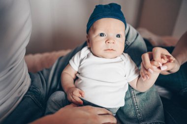 Bebeğini kucağında tutan mutlu ebeveynlerin yakın portresi. Genç, mutlu bir aile, anne ve baba yatak odasında yeni doğmuş tatlı bir çocukla oynuyorlar.