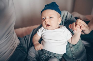 Bebeğini kucağında tutan mutlu ebeveynlerin yakın portresi. Genç, mutlu bir aile, anne ve baba yatak odasında yeni doğmuş tatlı bir çocukla oynuyorlar.