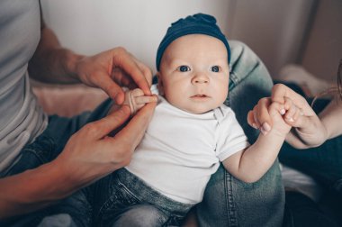 Bebeğini kucağında tutan mutlu ebeveynlerin yakın portresi. Genç, mutlu bir aile, anne ve baba yatak odasında yeni doğmuş tatlı bir çocukla oynuyorlar.
