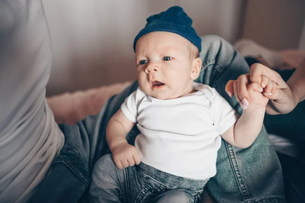 Bebeğini kucağında tutan mutlu ebeveynlerin yakın portresi. Genç, mutlu bir aile, anne ve baba yatak odasında yeni doğmuş tatlı bir çocukla oynuyorlar.