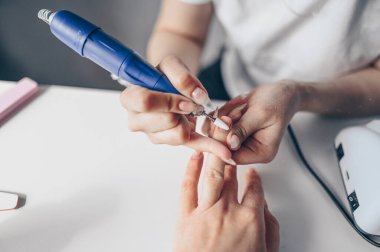 Hırdavatçı profesyonel manikür işlemi, değirmen bıçağıyla çivi temizleme. Güzellik salonunda kadın ellerini kapat. Tırnak tedavisi, işlem. Elektrikli çivi dosyası talimi devrede