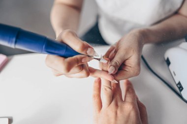 Hırdavatçı profesyonel manikür işlemi, değirmen bıçağıyla çivi temizleme. Güzellik salonunda kadın ellerini kapat. Tırnak tedavisi, işlem. Elektrikli çivi dosyası talimi devrede