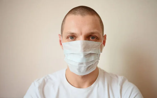 Close up portrait of young european man doctor wearing protective face mask corona virus prevention. Free space for text mockup banner. Avoid contaminating Corona virus Covid-19 concept