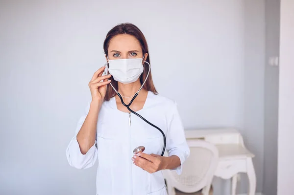 Woman doctor nurse wearing protective mask and stethoscope for check breathing, corona virus prevention, hygiene to stop spreading coronavirus. Avoid contaminating Corona virus Covid-19 concept