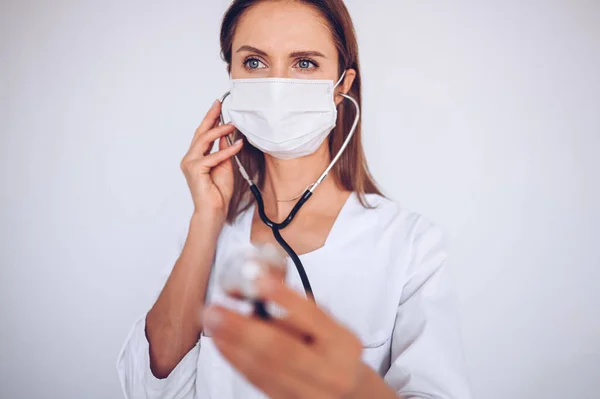 Woman doctor nurse wearing protective mask and stethoscope for check breathing, corona virus prevention, hygiene to stop spreading coronavirus. Avoid contaminating Corona virus Covid-19 concept