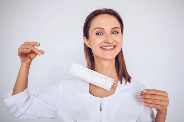 Close up portrait of beautiful young european smiling happy woman doctor nurse wearing protective mask corona virus prevention. Free space for text mockup banner. Avoid contaminating Corona virus Covid-19 concept