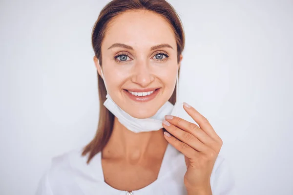 Close up portrait of beautiful young european smiling happy woman doctor nurse wearing protective mask corona virus prevention. Free space for text mockup banner. Avoid contaminating Corona virus Covid-19 concept