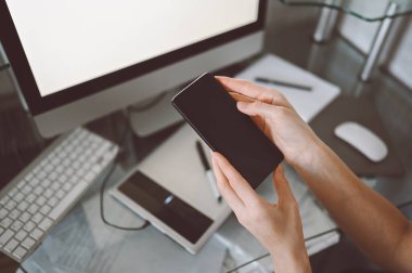 İç işlerinde akıllı telefon kullanan kadın eller, ofis masasında cep telefonu kullanan serbest çalışan iş kadını, akıllı telefon ve bilgisayar kullanarak evden çalışan. Uzaktan işçi karantinası