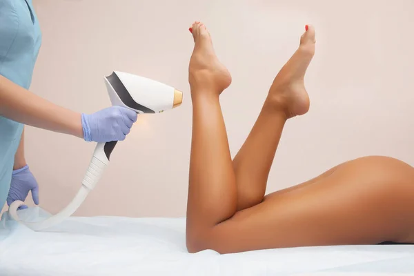 Güzellik salonunda lazer epilasyonu ve kozmetoloji. Saç çıkarma prosedürü. Lazer epilasyonu, kozmetoloji, spa ve saç temizleme konsepti. Güzel bir kadın saçlarını kestiriyor.