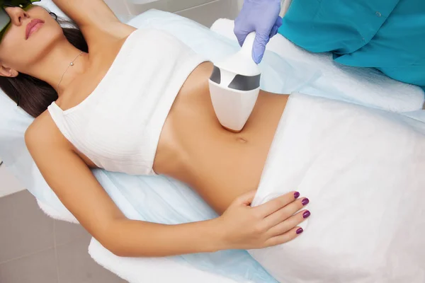 Güzellik salonunda lazer epilasyonu ve kozmetoloji. Saç çıkarma prosedürü. Lazer epilasyonu, kozmetoloji, spa ve saç temizleme konsepti. Güzel bir kadın kıllarını aldırıyor.