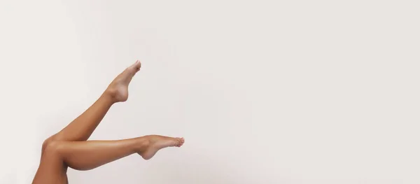 女人的身体护理 细长的雌性晒黑的腿与完美的光滑柔软的皮肤 健康的指甲白色背景 美及健康概念 — 图库照片