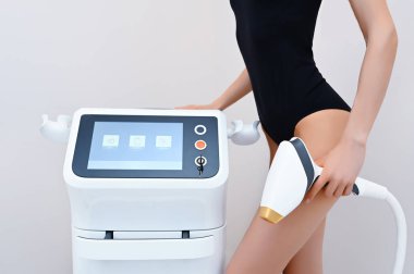 Güzel, formda, yumuşak tenli, siyah iç çamaşırlı ve güzellik salonuna izole edilmiş lazer cihazlı bir kadın vücudu. Saç aldırma ve kozmetoloji. Epilasyon spa konsepti. Metin pankartı için boş alan