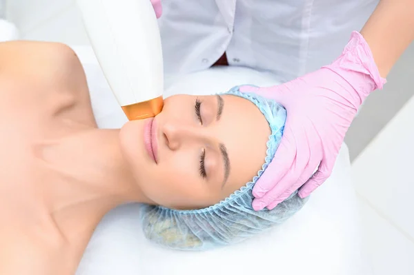 Anti-aging procedures. Skin care concept. Woman receiving facial beauty treatment, removing pigmentation at cosmetic clinic. Intense pulsed light therapy. IPL. Rejuvenation, photo facial therapy.