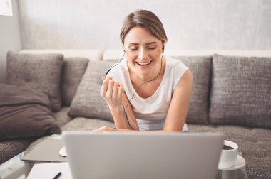 Çekici mutlu genç öğrenci evde online çalışıyor, dizüstü bilgisayar, kulaklık kullanıyor, görüntülü konuşma yapıyor, el sallıyor. Uzaktan çalışma, uzaktan eğitim. Karantina ile ilgili video konferansı veya sanal olay