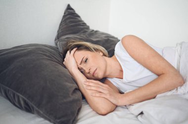 Depresyondaki kadın huzursuz uykusuzluktan bitkin düşmüş ve uykusuzluk, kötü rüyalar, kabuslar, psikolojik sorunlar yaşıyor. Rahatsız edici yatak ya da yatak. Uyku eksikliği.