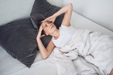 Depresyondaki kadın huzursuz uykusuzluktan bitkin düşmüş ve uykusuzluk, kötü rüyalar, kabuslar, psikolojik sorunlar yaşıyor. Rahatsız edici yatak ya da yatak. Uyku eksikliği.