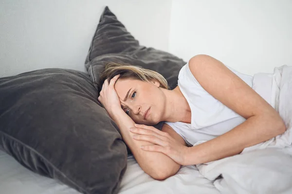Depresyondaki kadın huzursuz uykusuzluktan bitkin düşmüş ve uykusuzluk, kötü rüyalar, kabuslar, psikolojik sorunlar yaşıyor. Rahatsız edici yatak ya da yatak. Uyku eksikliği.