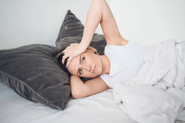 Depresyondaki kadın huzursuz uykusuzluktan bitkin düşmüş ve uykusuzluk, kötü rüyalar, kabuslar, psikolojik sorunlar yaşıyor. Rahatsız edici yatak ya da yatak. Uyku eksikliği.