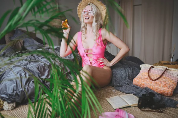 幸せなセクシーブロンドの女性でピンクの水着模倣夏のビーチ休暇時間に自宅の寝室のインテリア 観光旅行業界のコロナウイルスの状況 楽しい隔離だ 家にいて孤立して — ストック写真