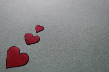 Aydınlık ya da gri arkaplanda kırmızı kalpler