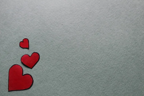 Aydınlık ya da gri arkaplanda kırmızı kalpler