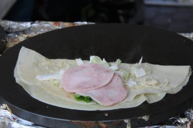 Jambon, mantar, beyaz sos ve sebzelerle doldurulmuş bir krep.