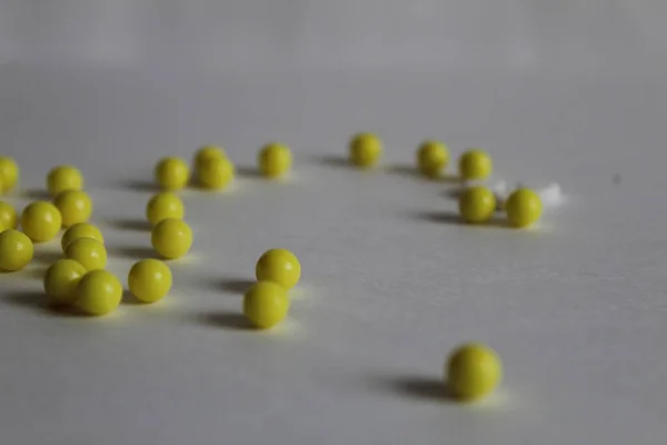 Sárga Vitaminok Vagy Tabletták Fehér Alapon Szétszóródnak Asztalon — Stock Fotó