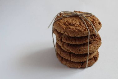 Yığılmış kuledeki yuvarlak kurabiyeler beyaz ışık arka planında ip sicimle bağlanmış.