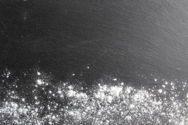 Koyu gri tahta un ya da pudra şekerle kaplanmış.