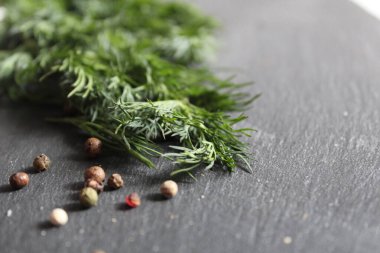 Gri siyah arkaplanda kırmızı siyah beyaz dereotu ve biber filizi.