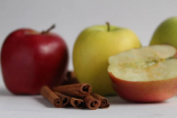 cinnamon sticks and apples on a white background