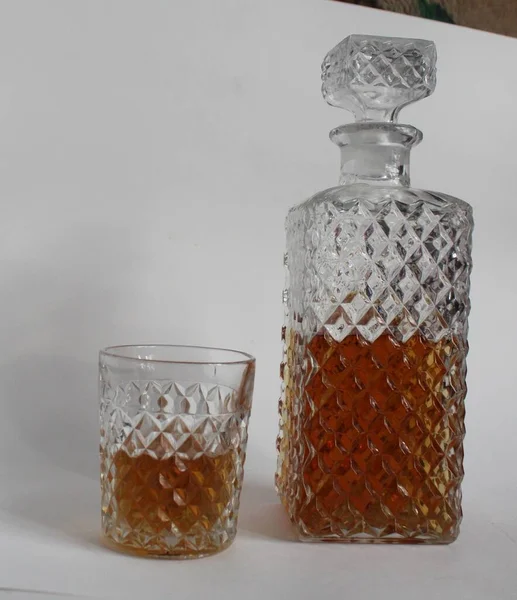 Bir flütlü damaske sürahisi bir şişe konyak ya da siyah arka planda bir viski fotokopi uzayının parlak güneşi tarafından aydınlatılır.