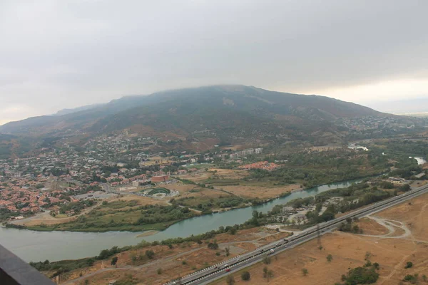 Kraliçe Tamara dağının manzarası evin eteğindeki sisin içinde nehir ve Georgia otoyolu akıyor.