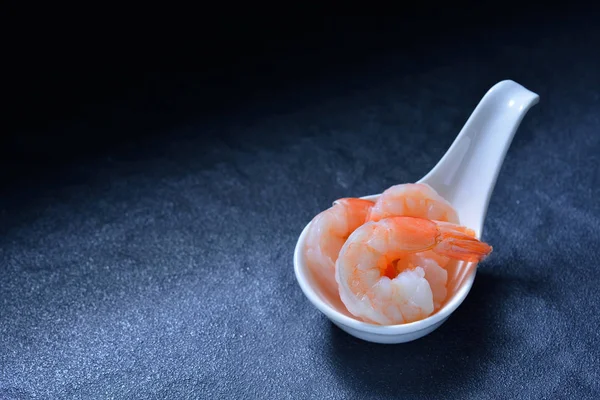 Camarones cocidos, langostinos en cuchara sobre fondo de piedra —  Fotos de Stock