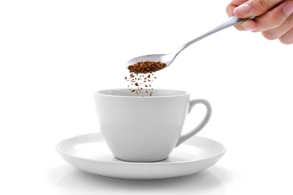 Рука наливает растворимый кофе из ложки в чашку кофе — стоковое фото