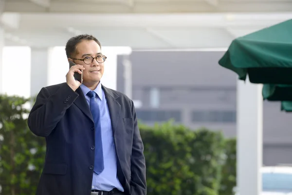 Empresário executivo falando em um telefone celular no escritório ao ar livre — Fotografia de Stock